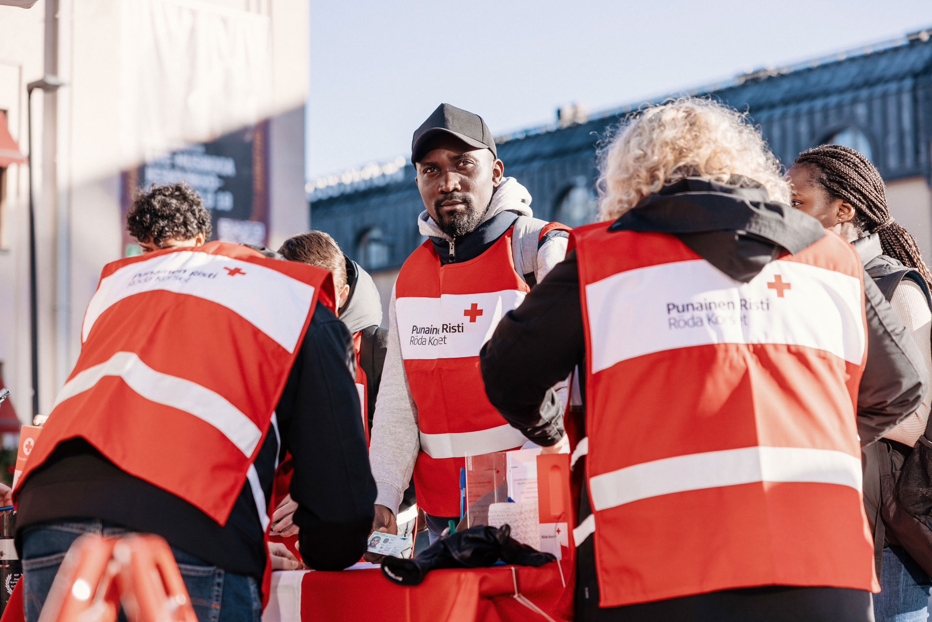 Nuoria nälkäpäivä lippaat käsissä ja keräysliivit päällään.