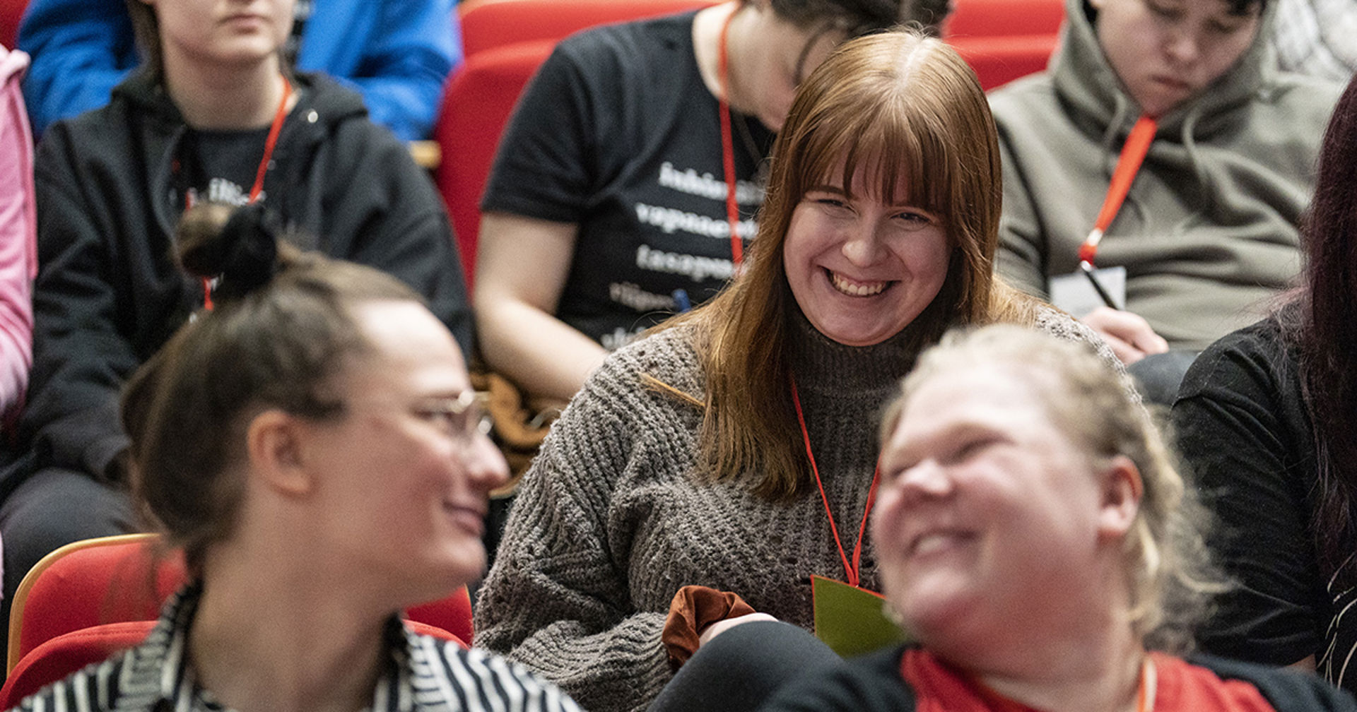 Kolme vapaaehtoista hymyilevät toisilleen.