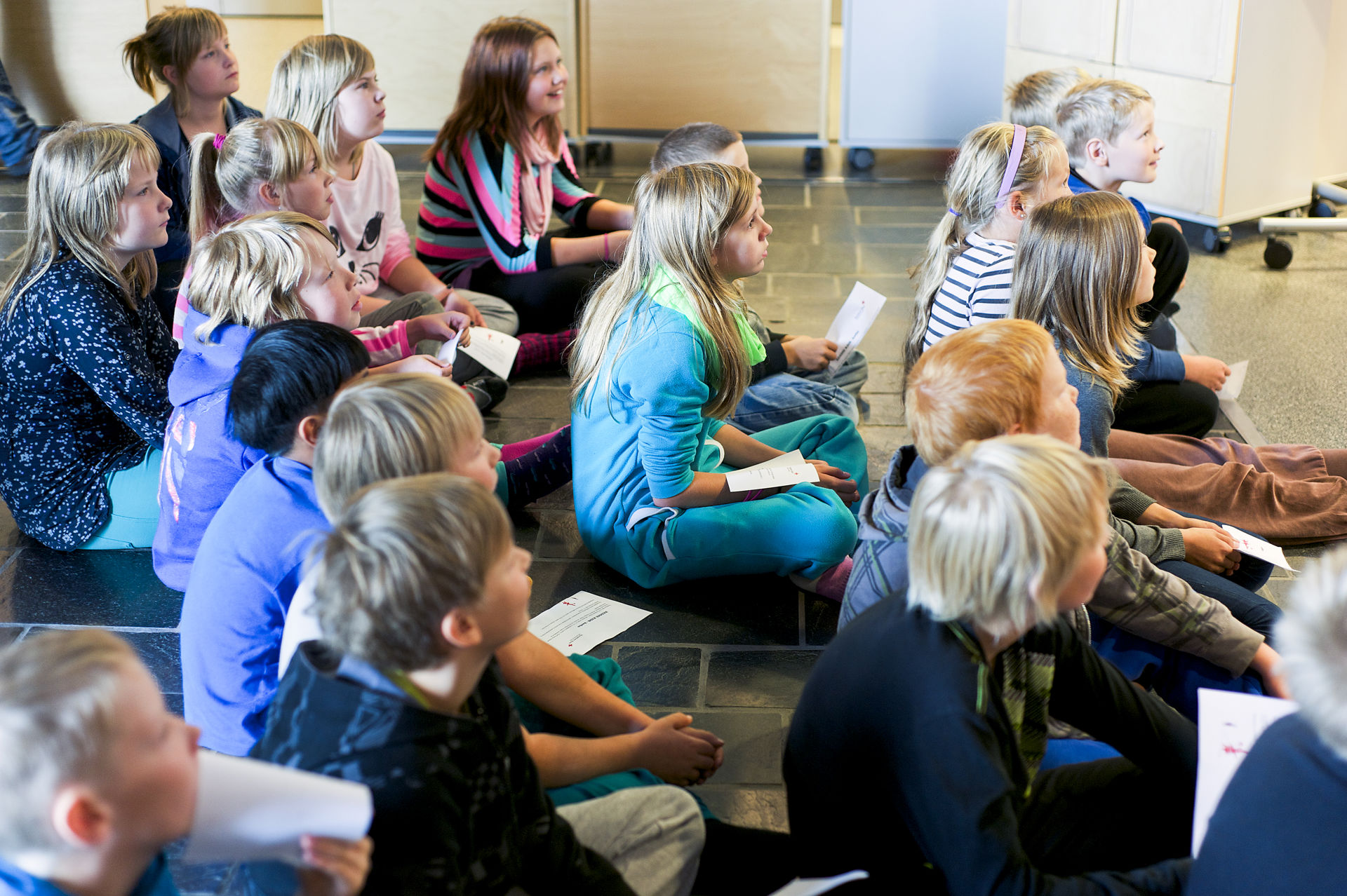 Lapsia istuu lattialla.