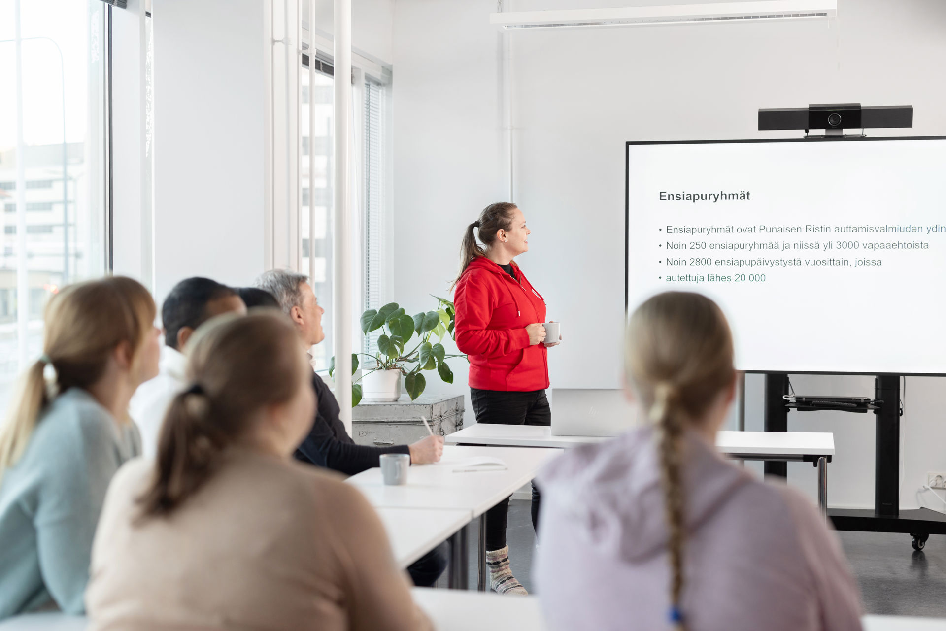 Punaisen Ristin vapaaehtoinen katsoo valkotaulua opetustilassa.