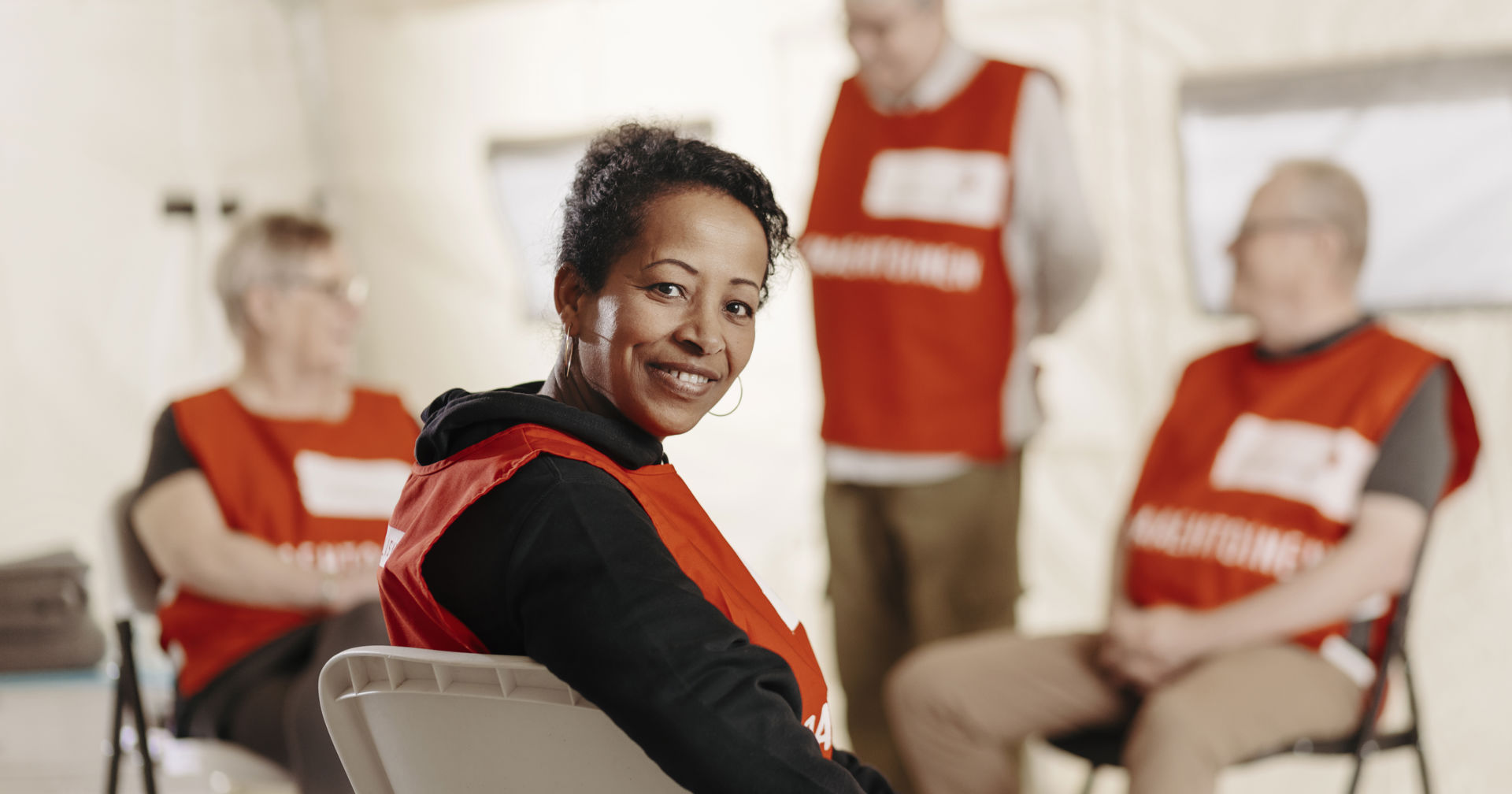 Vapaaehtoinen katsoo hymyillen kohti kameraa.