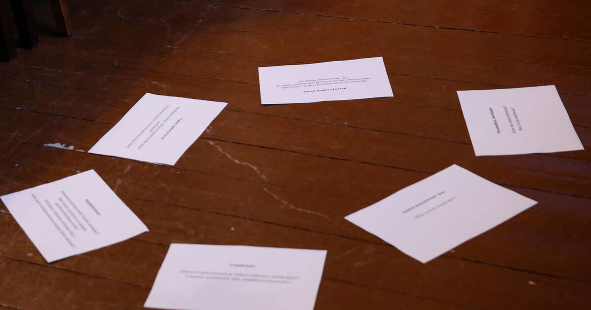 Lattialla on papereita aseteltuna ympyrän muotoon.