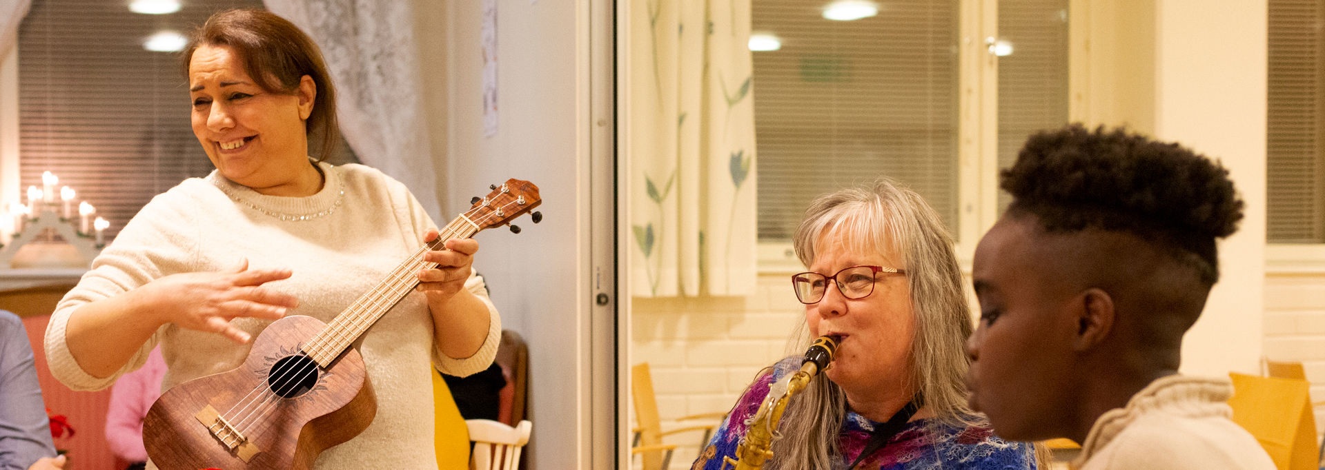 Kolme henkilöä soittaa ja laulaa yhdessä.