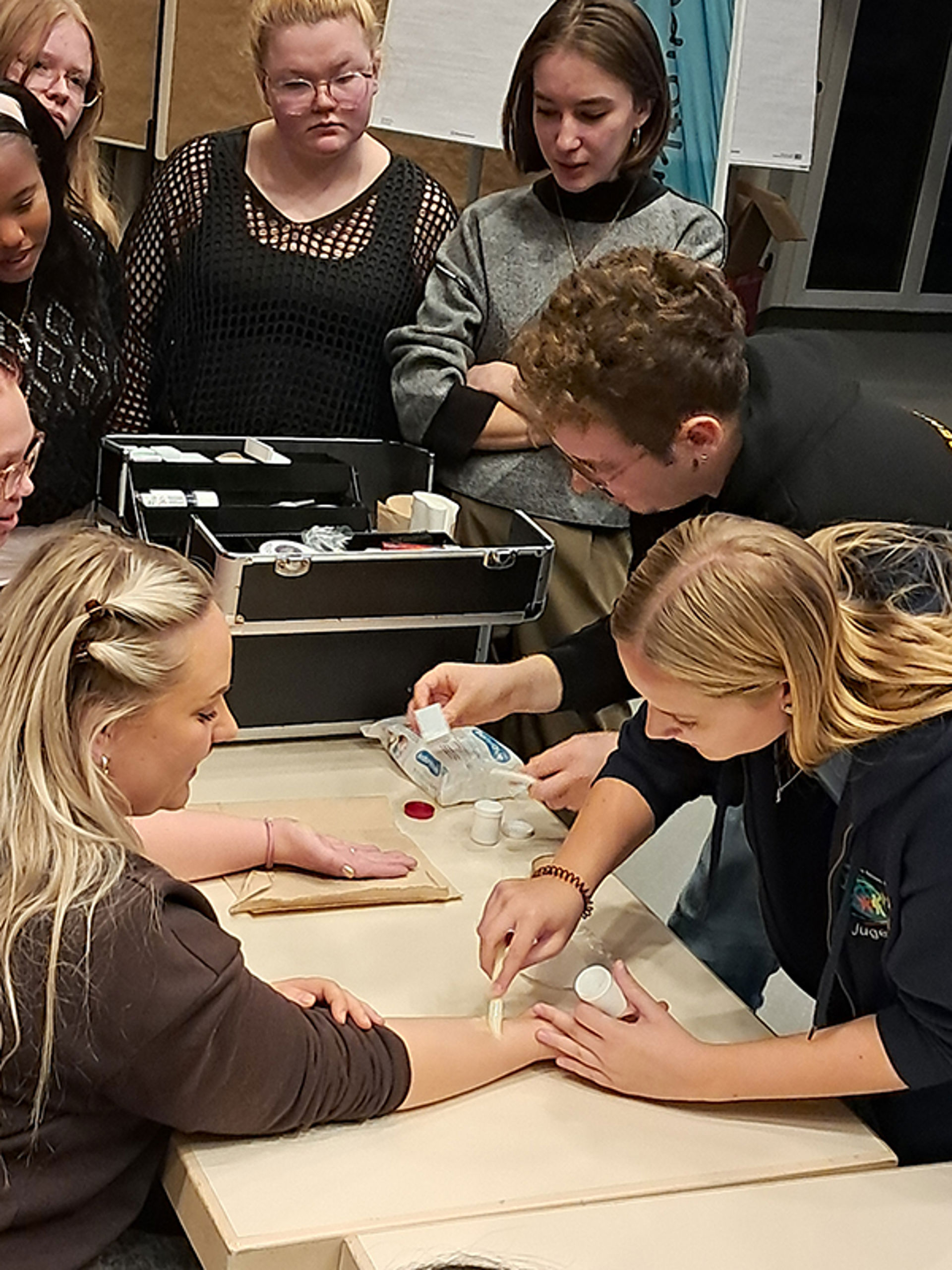 Augsburgissa Nuorten Punaisen Ristin tapaamisessa esiteltiin lasten kerhojen ohjaajien maskeeraustaitoja, joita tarvitaan lasten ensiaputaitojen opetuksessa. ”Mitä aidomman näköinen vamma, sitä innokkaammin lapset harjoittelevat sitomistaitoja”, kertoi vapaaehtoisena toimiva Emma.