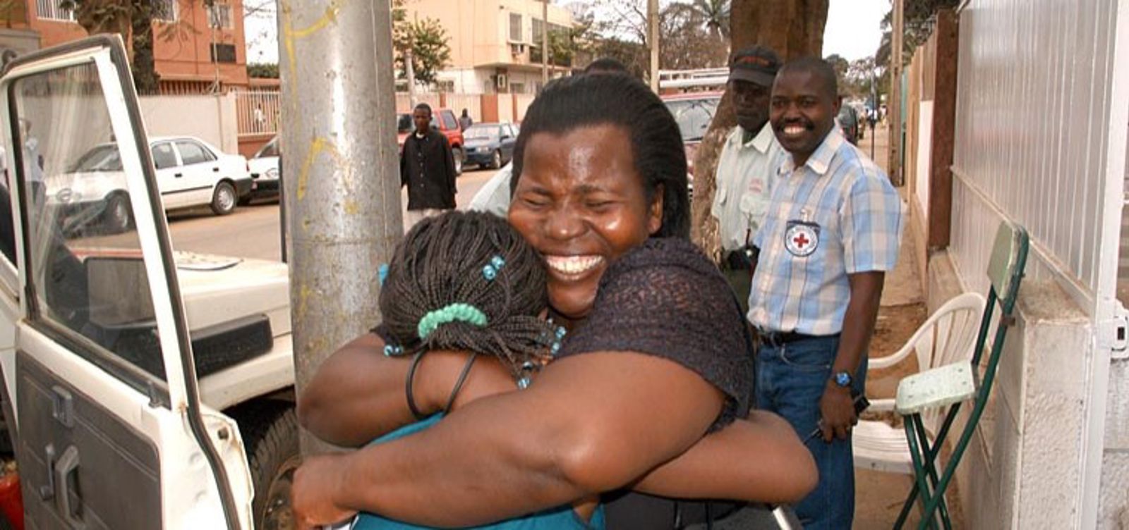 Henkilö halaa toista henkilöä ja hymyilee onnellisesti.