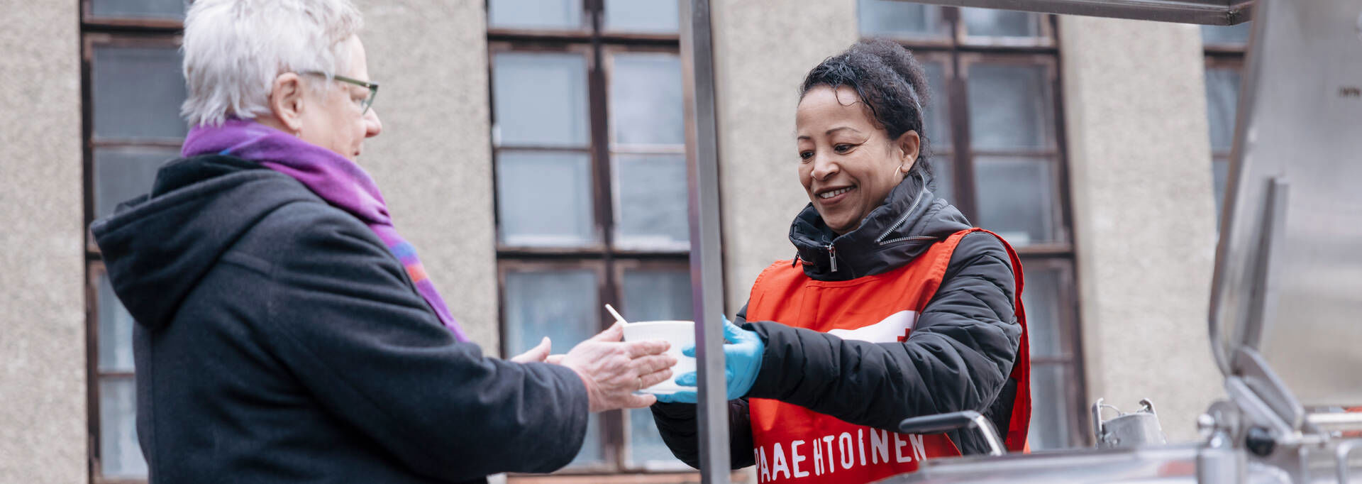 Vapaaehtoinen ojentaa ruokaa ruoka-apua hakevalle.
