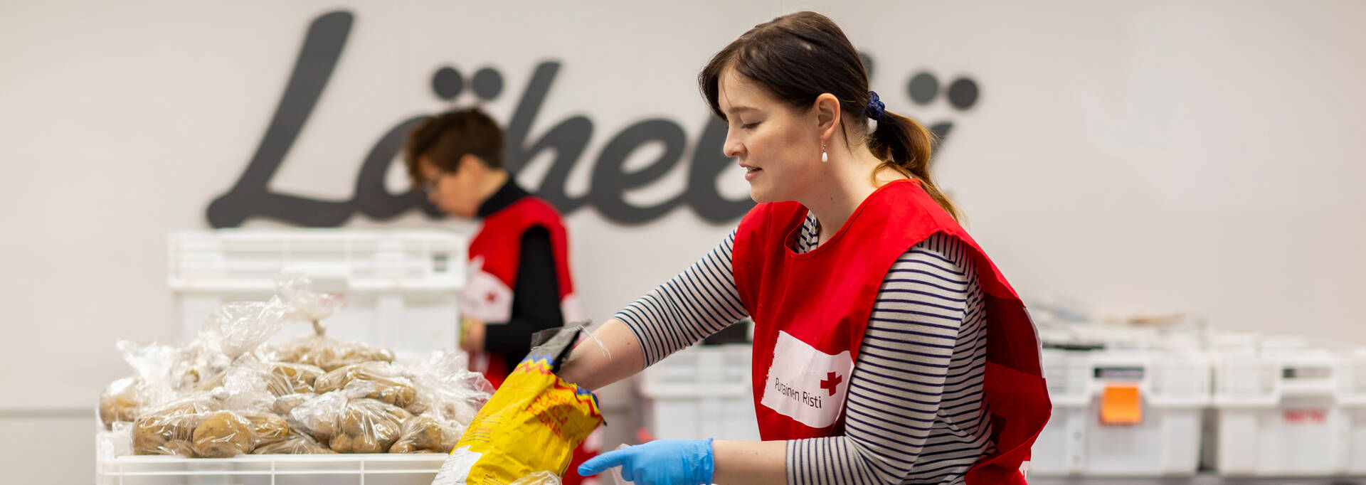 Suomen Punaisen Ristin vapaaehtoinen pakkaa ruokapusseja.