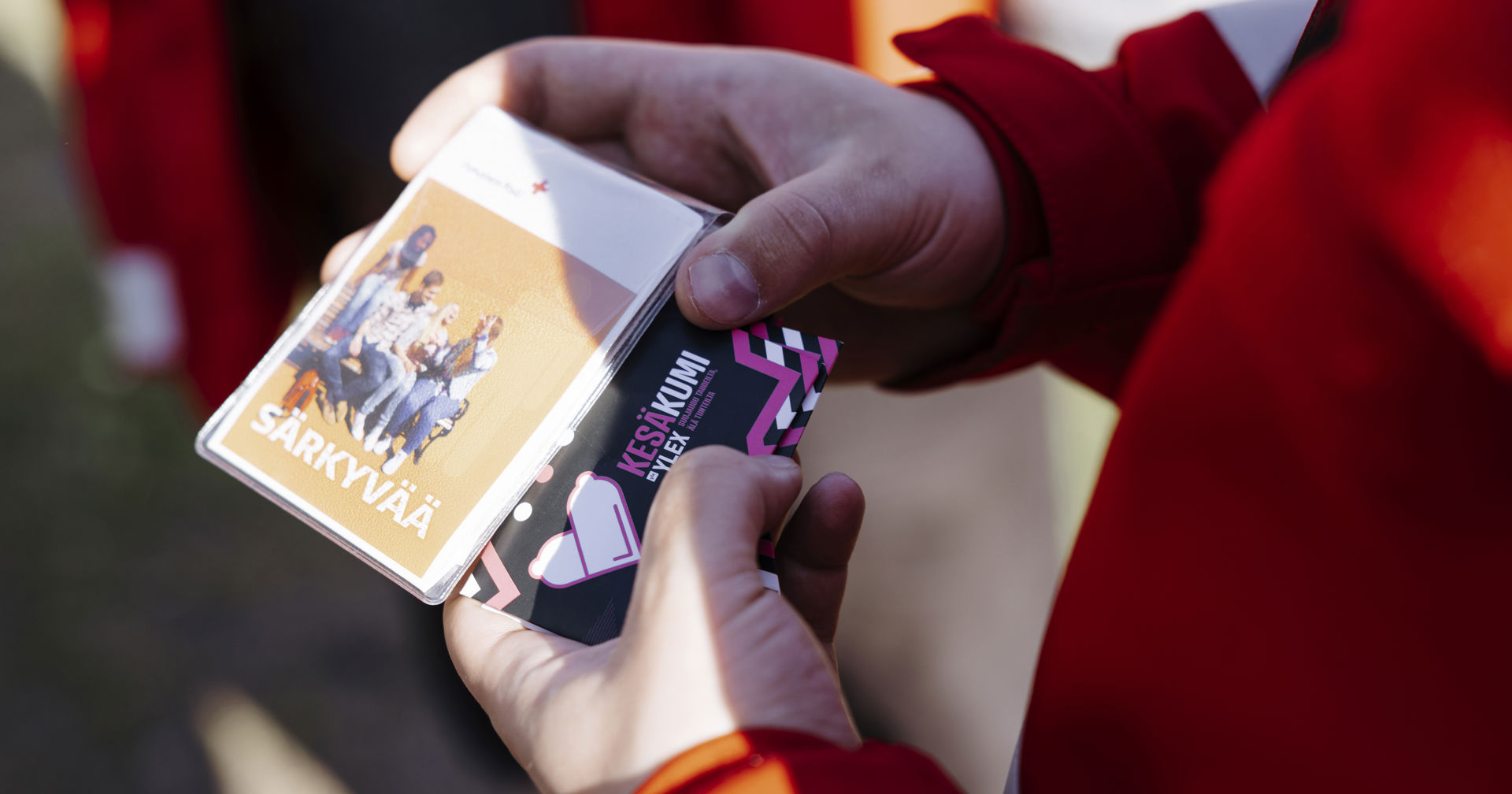 Kädet pitelevät kesäkumia ja särkyvää-nimistä esitettä.