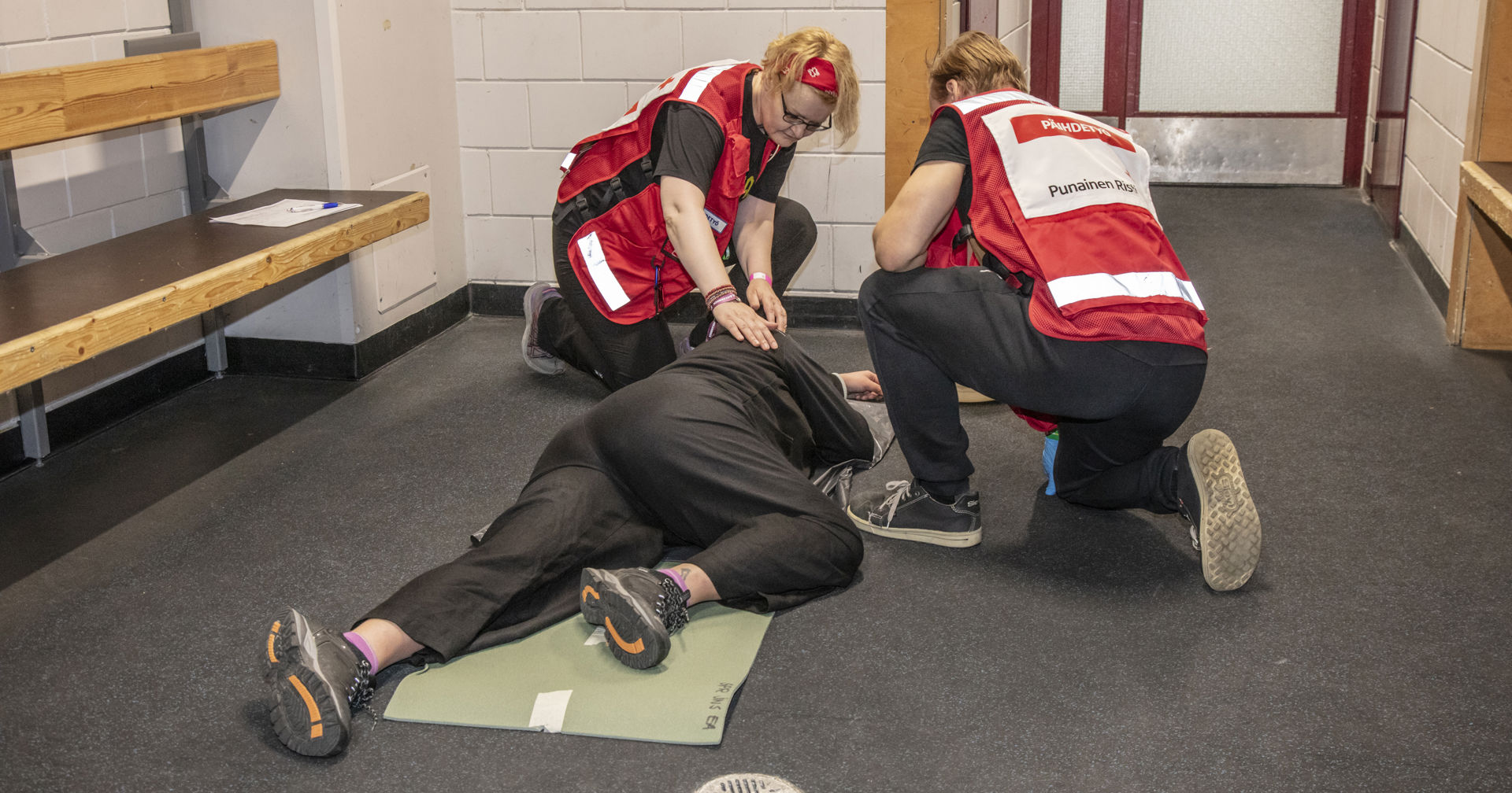 Suomen Punaisen Ristin selviämispisteen vapaaehtoiset ovat auttaneet henkilön kylkiasentoon.