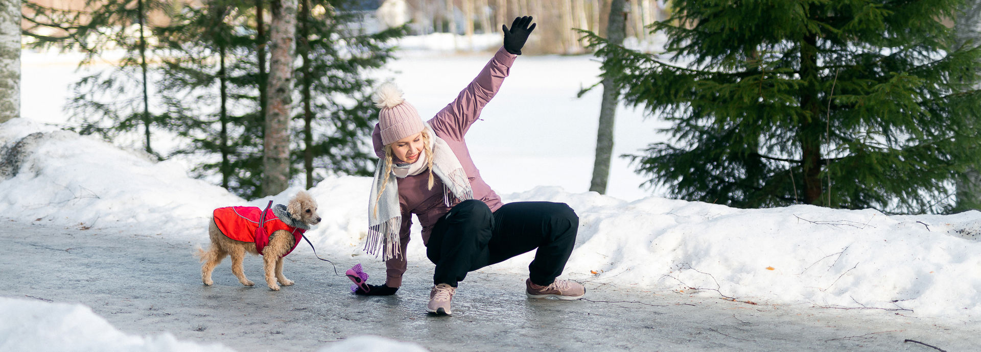 Henkilö liukastuu jäällä talvisessa maisemassa.