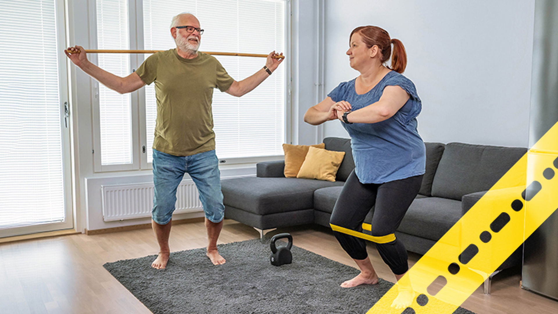 Kaksi henkilöä jumppaa olohuoneessa. 