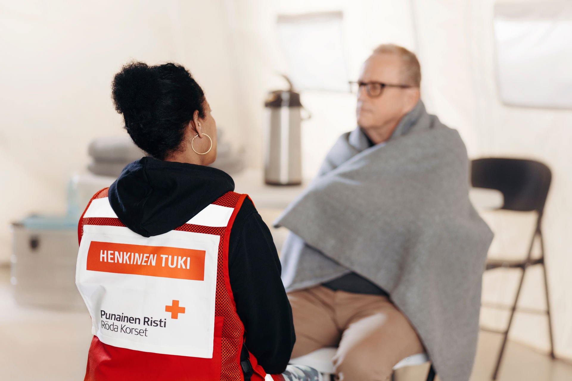 Vapaaehtoinen antaa henkistä tukea henkilölle, jolla on viltti ympärillä.