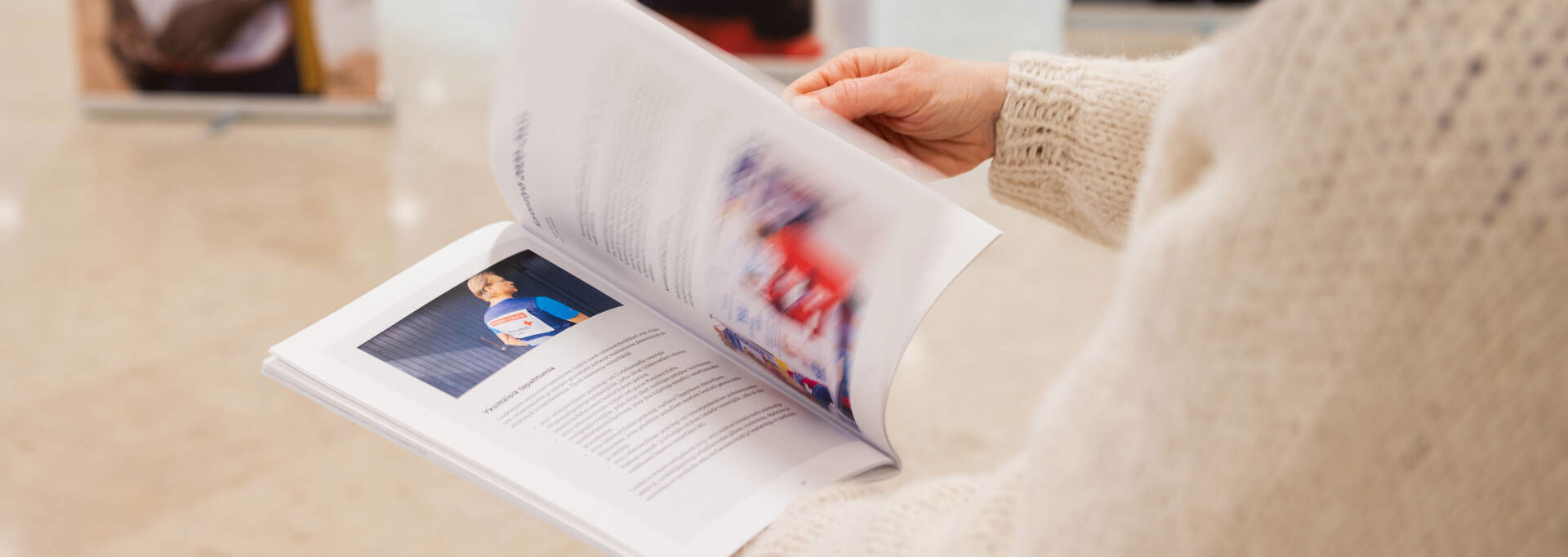 Kädet selaavat lehtistä.