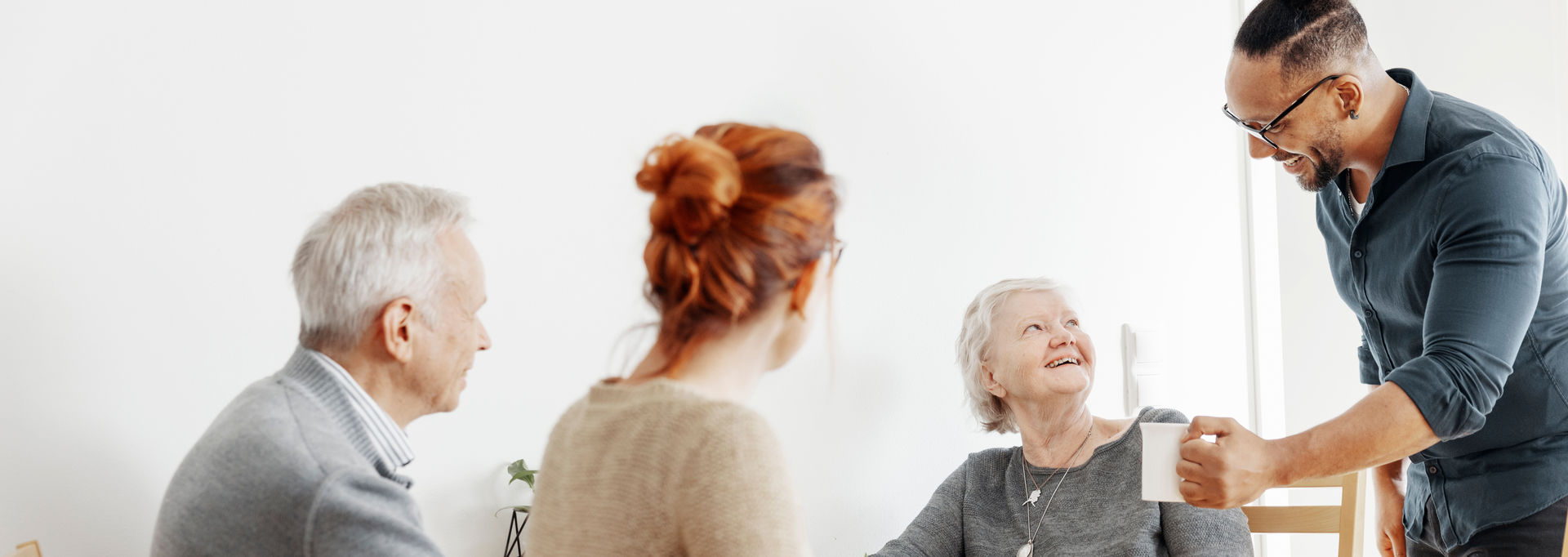 Neljä henkilöä pöydän ääressä.