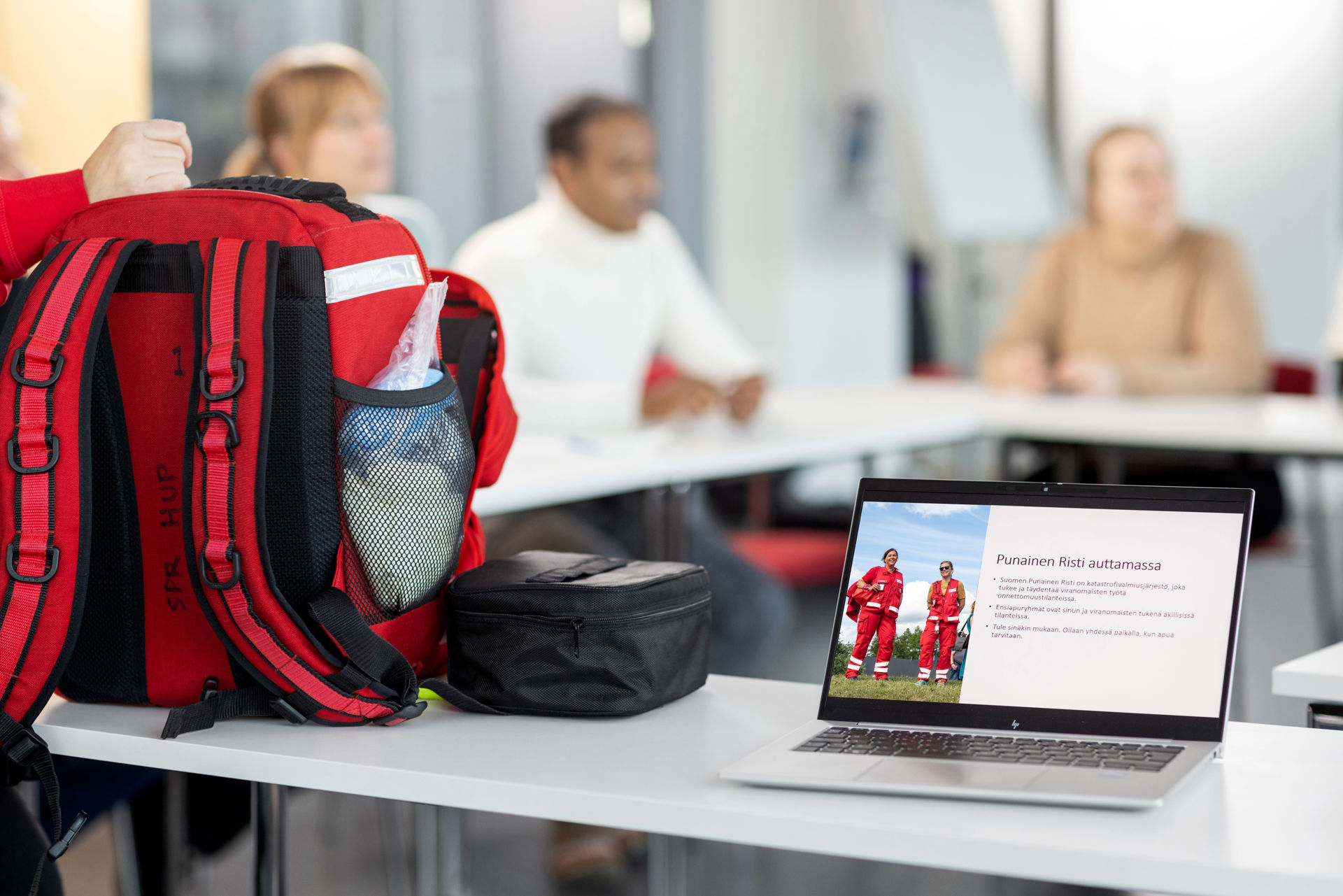 Reppu ja päällä oleva kannatteva tietokone pöydällä.
