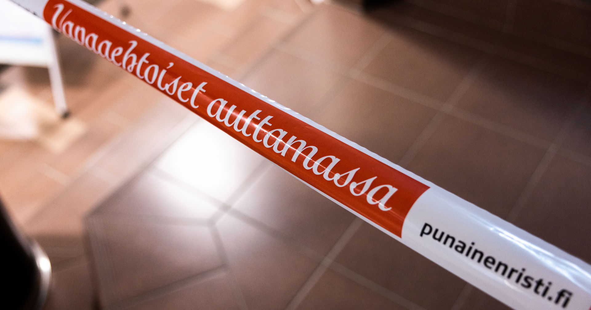 Muovinauhassa lukee: Vapaaehtoiset auttamassa, PunainenRisti.fi.