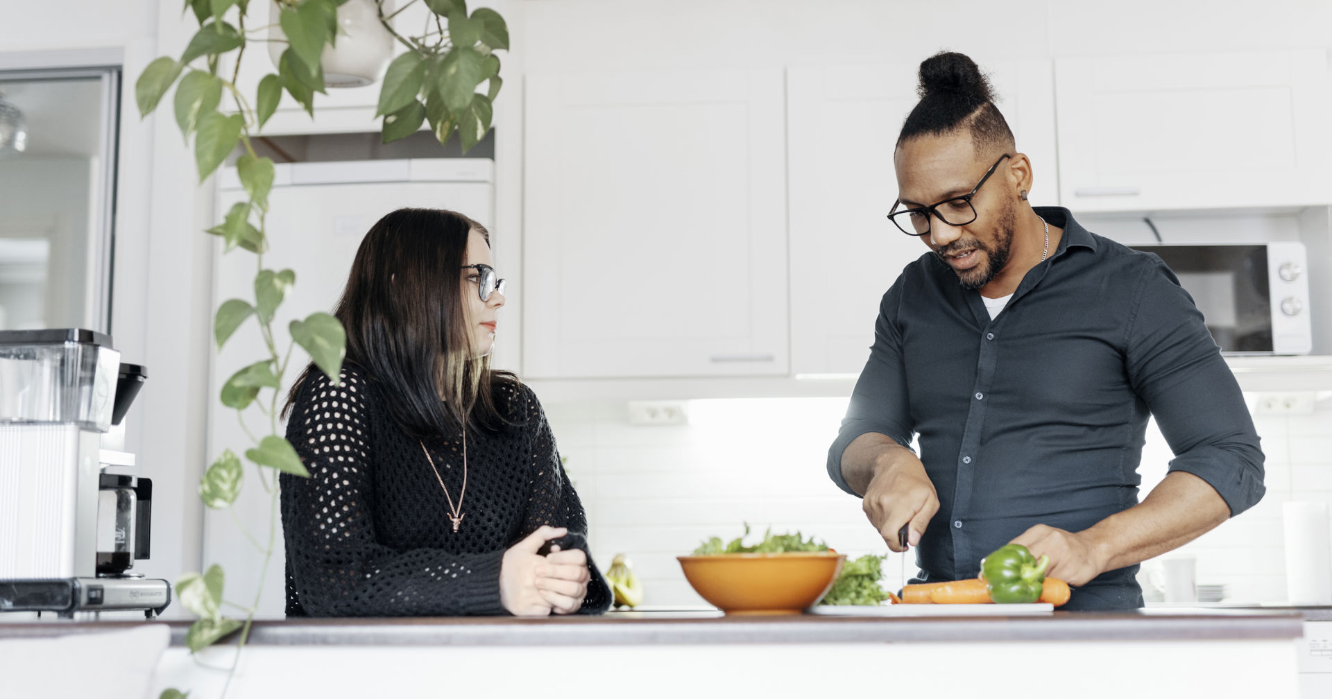 Kaksi henkilöä juttelee keittiössä.