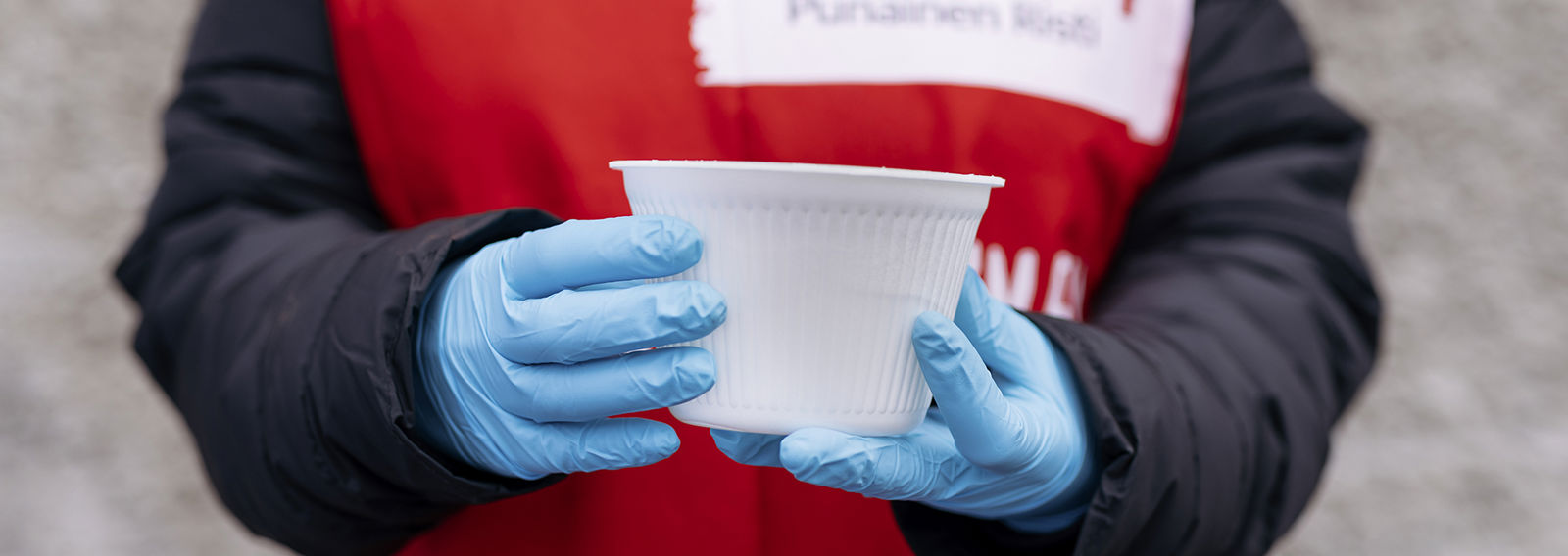 Kädet pitelevät soppakulhoa.