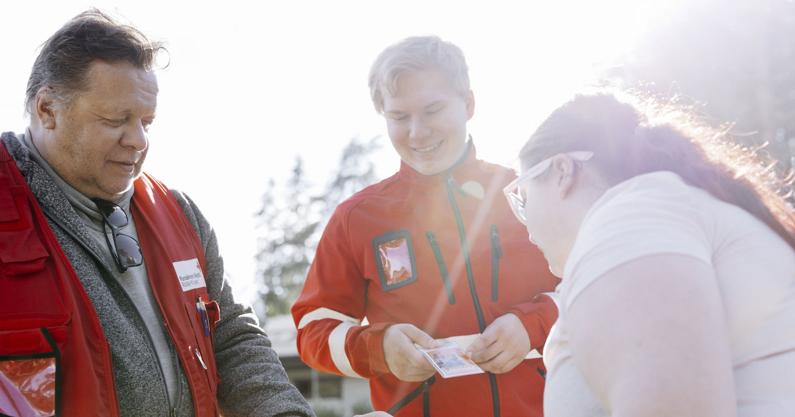 Suomen Punaisen Ristin päihdetyön vapaaehtoiset tarjoavat nuorelle esitteitä.