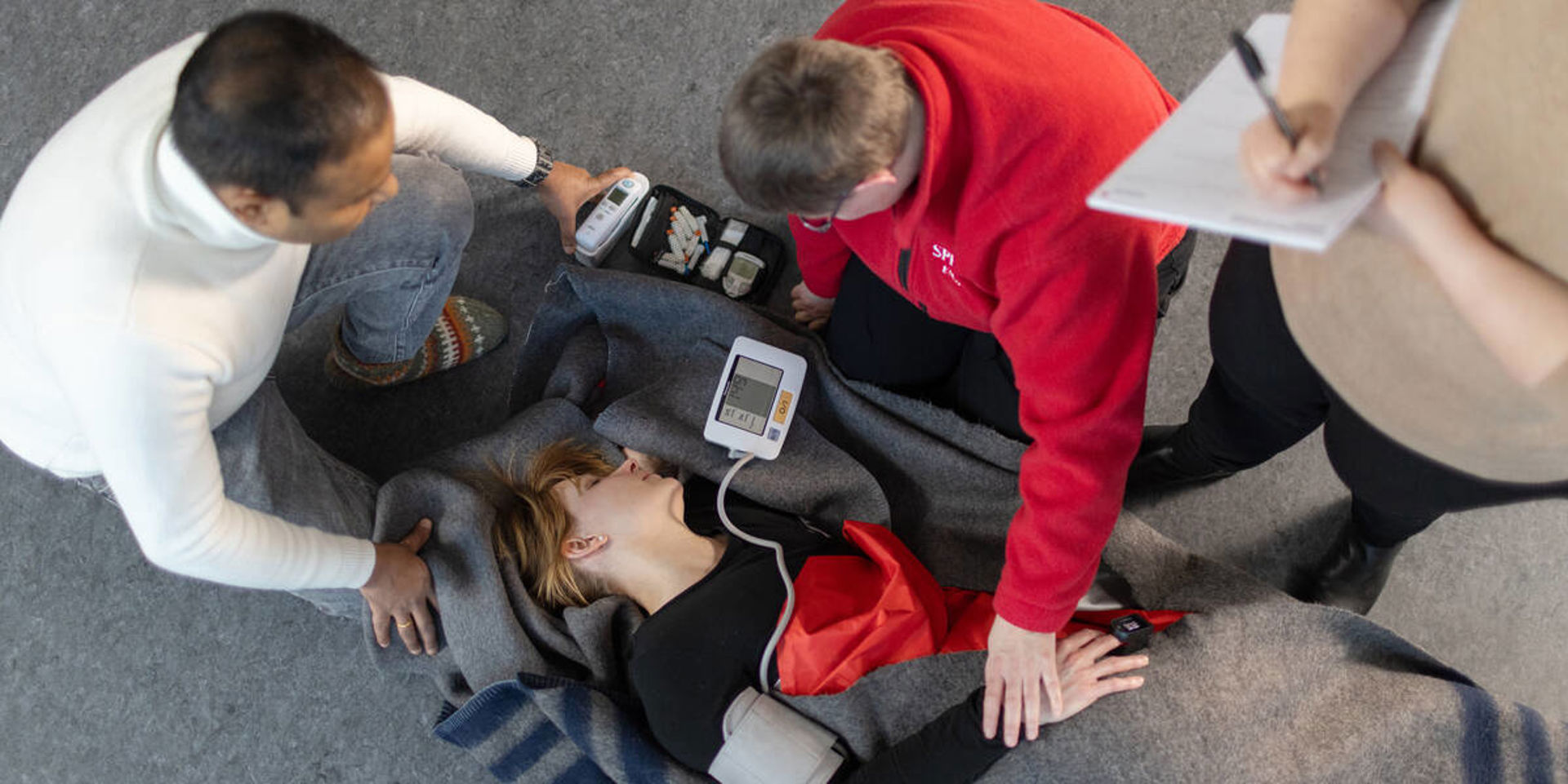 Kaksi henkilöä harjoittelee henkilön kantamista paareilla.