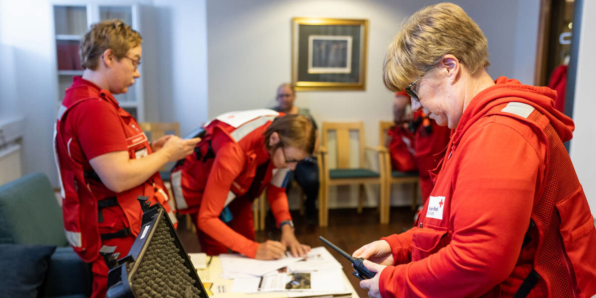 Kolme henkilöä pöydän ympärillä.