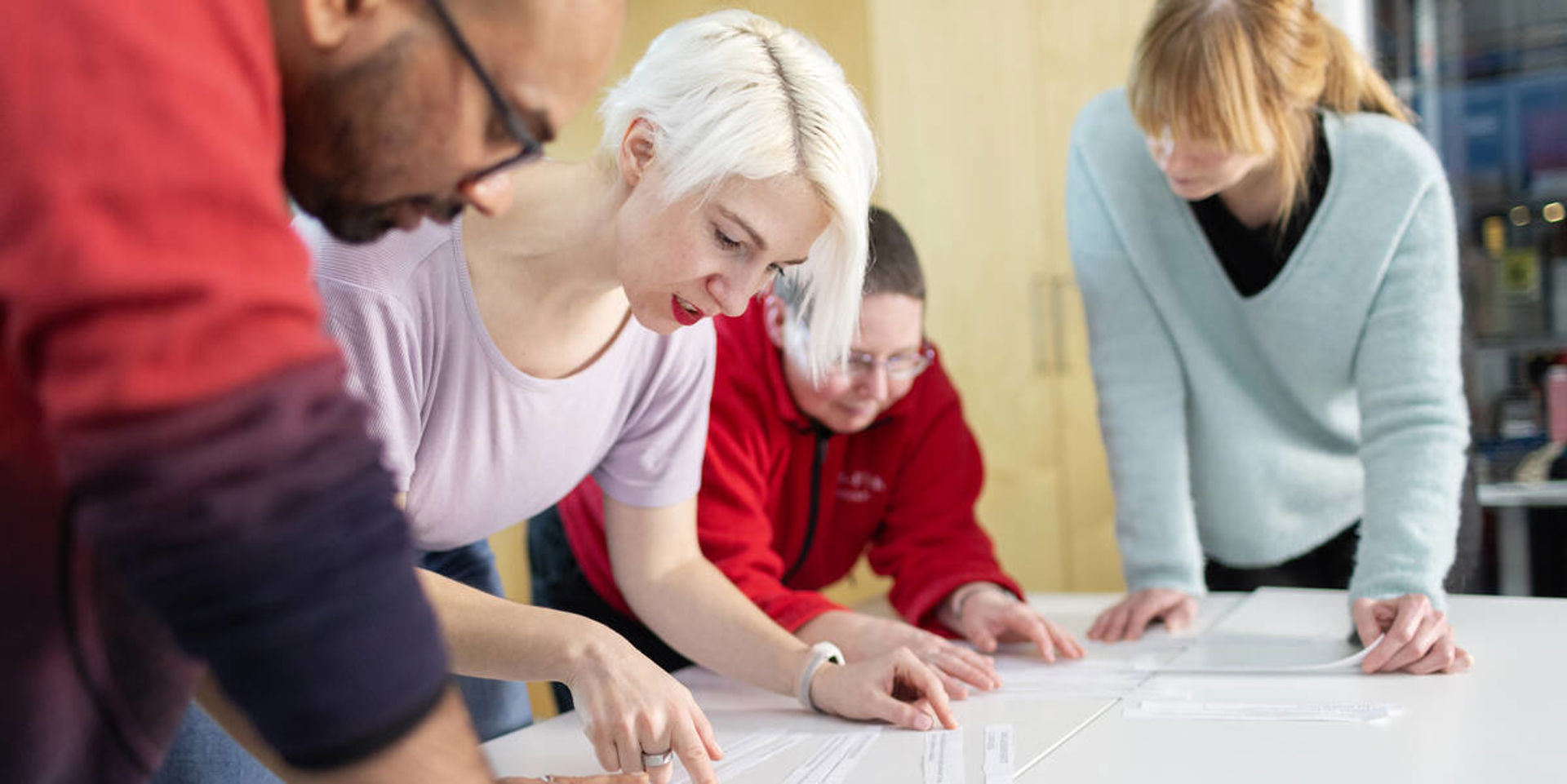 Neljä henkilöä pöydän ääressä.