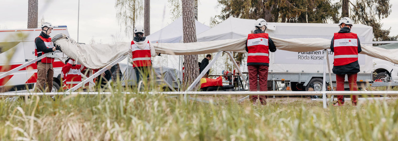 Vapaaehtoiset kantavat tavaroita yhdessä autosta.