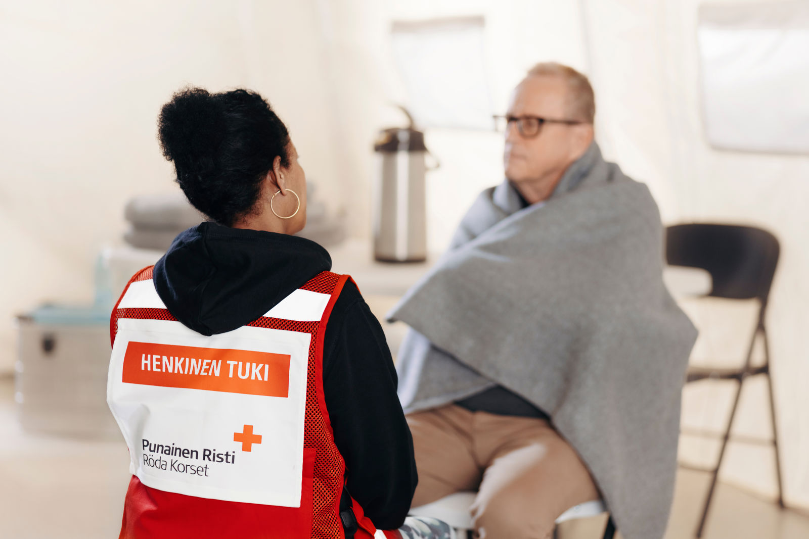 Vapaaehtoinen antaa henkistä tukea henkilölle, jolla on viltti ympärillä.