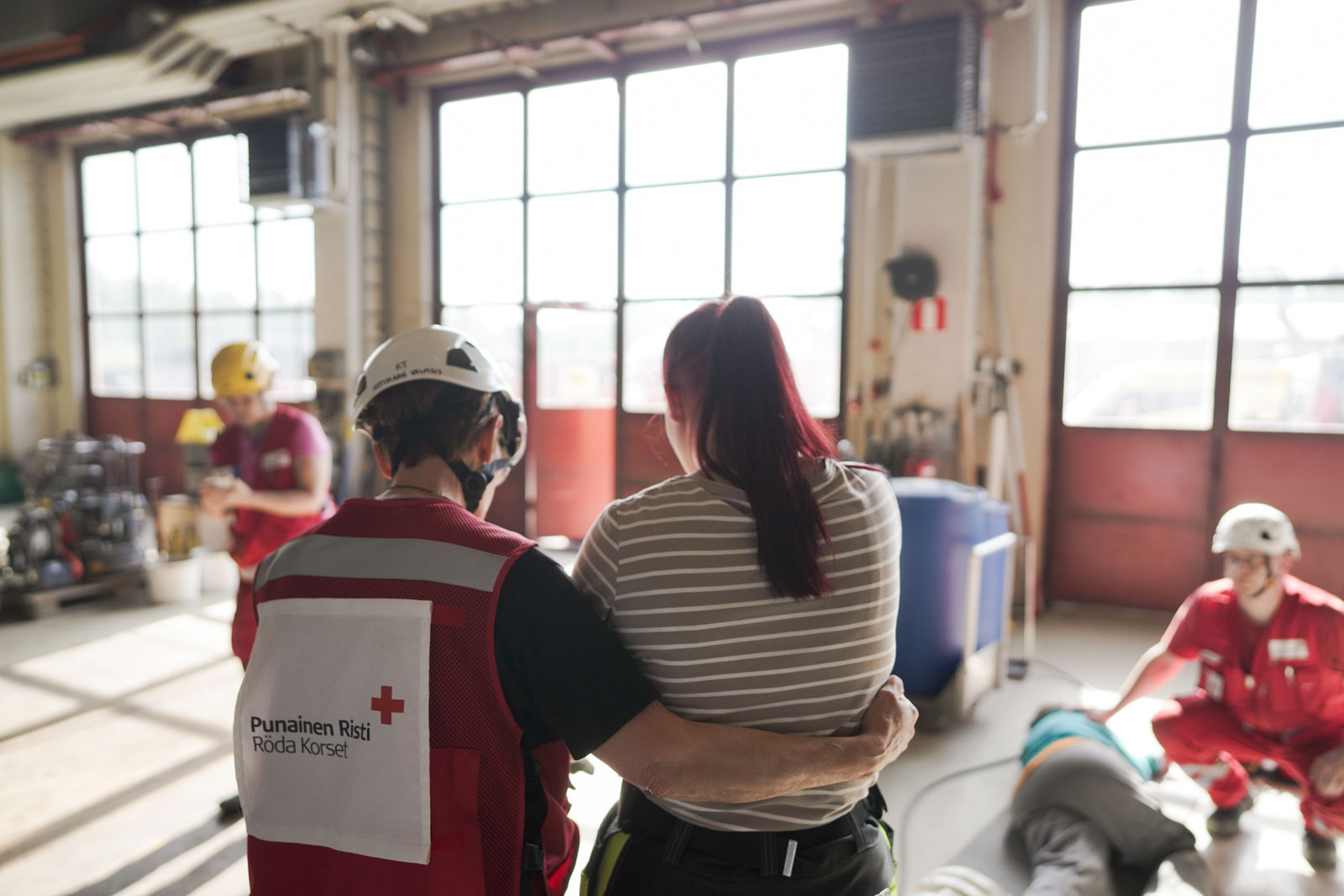 Punaisen Ristin vapaaehtoinen lohduttaa henkilöä.