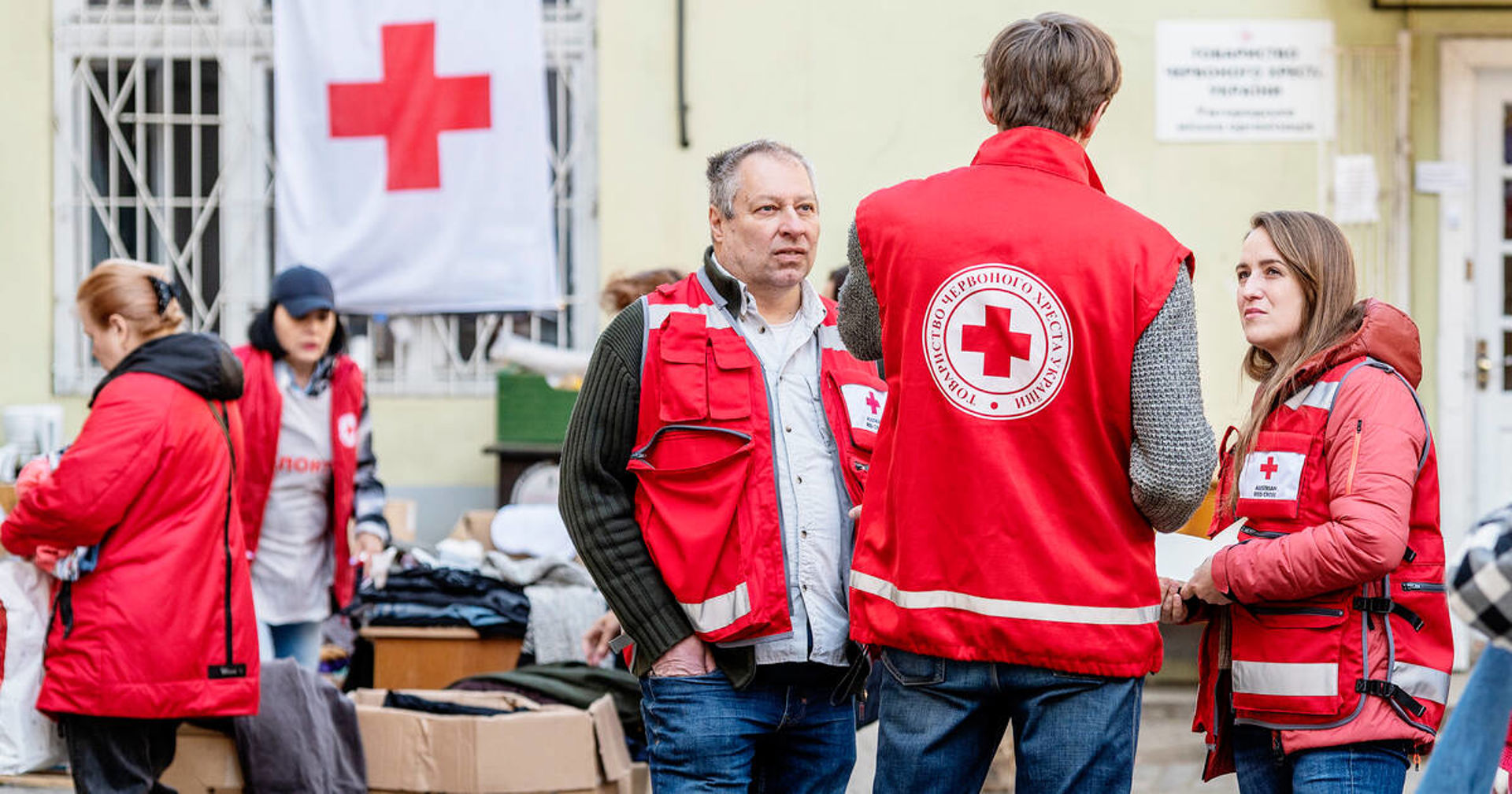 Punaisen Ristin katastrofivalmiusyksikön työntekijöitä valmistelemassa hätäapua. Taustalla näkyy laatikoita ja rekka. 