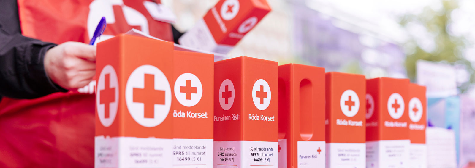 Punaisen Ristin keräyslippaita rivissä.