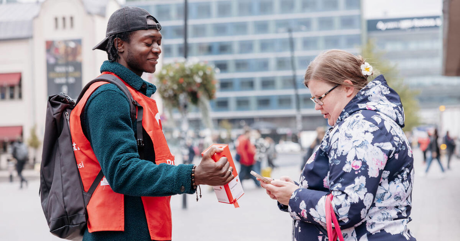 Henkilö kuvaa vapaaehtoisen keräyslipasta.