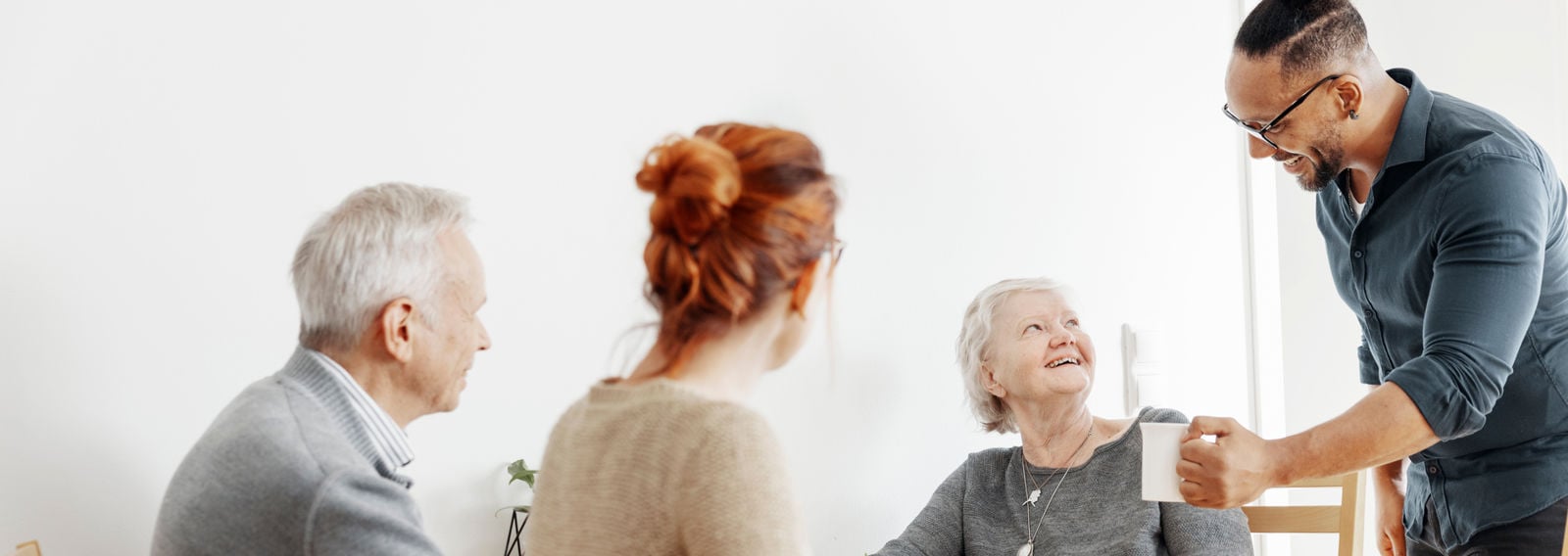 Neljä henkilöä pöydän ääressä.