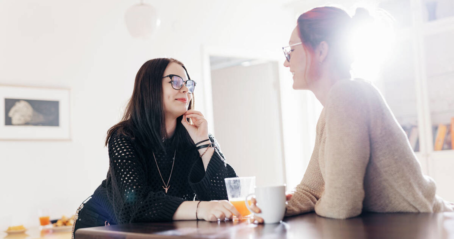 Two people talking around a kitchen island.