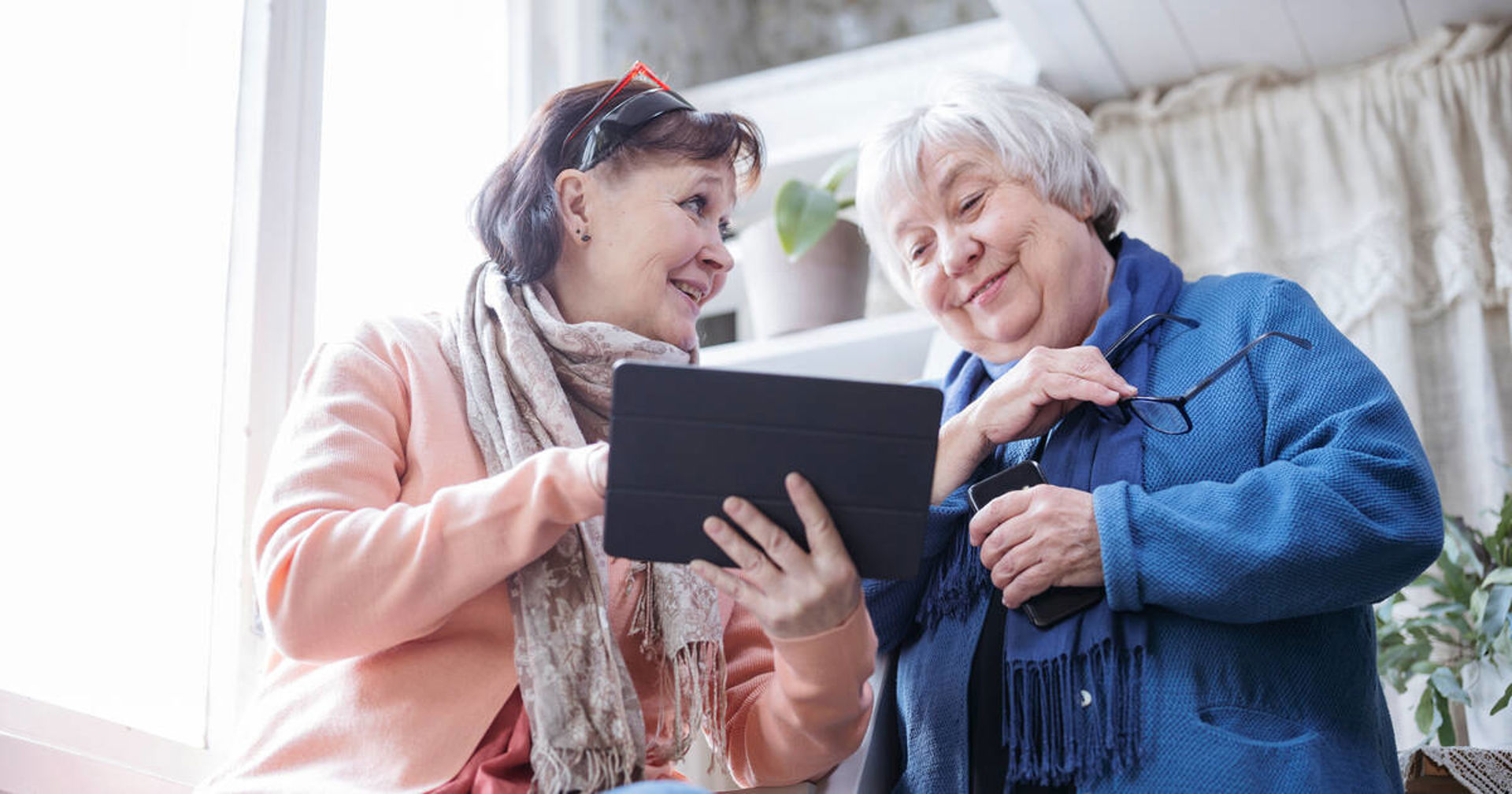 Kaksi henkilöä katsovat jotain tabletilta.