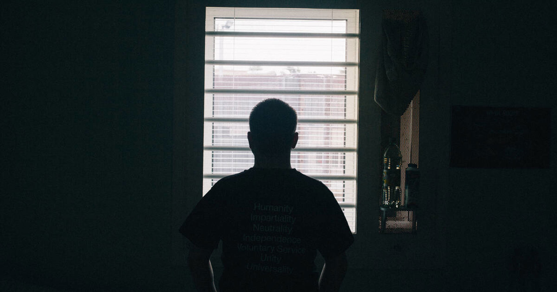 Henkilö silhuettina ikkunan edessä.