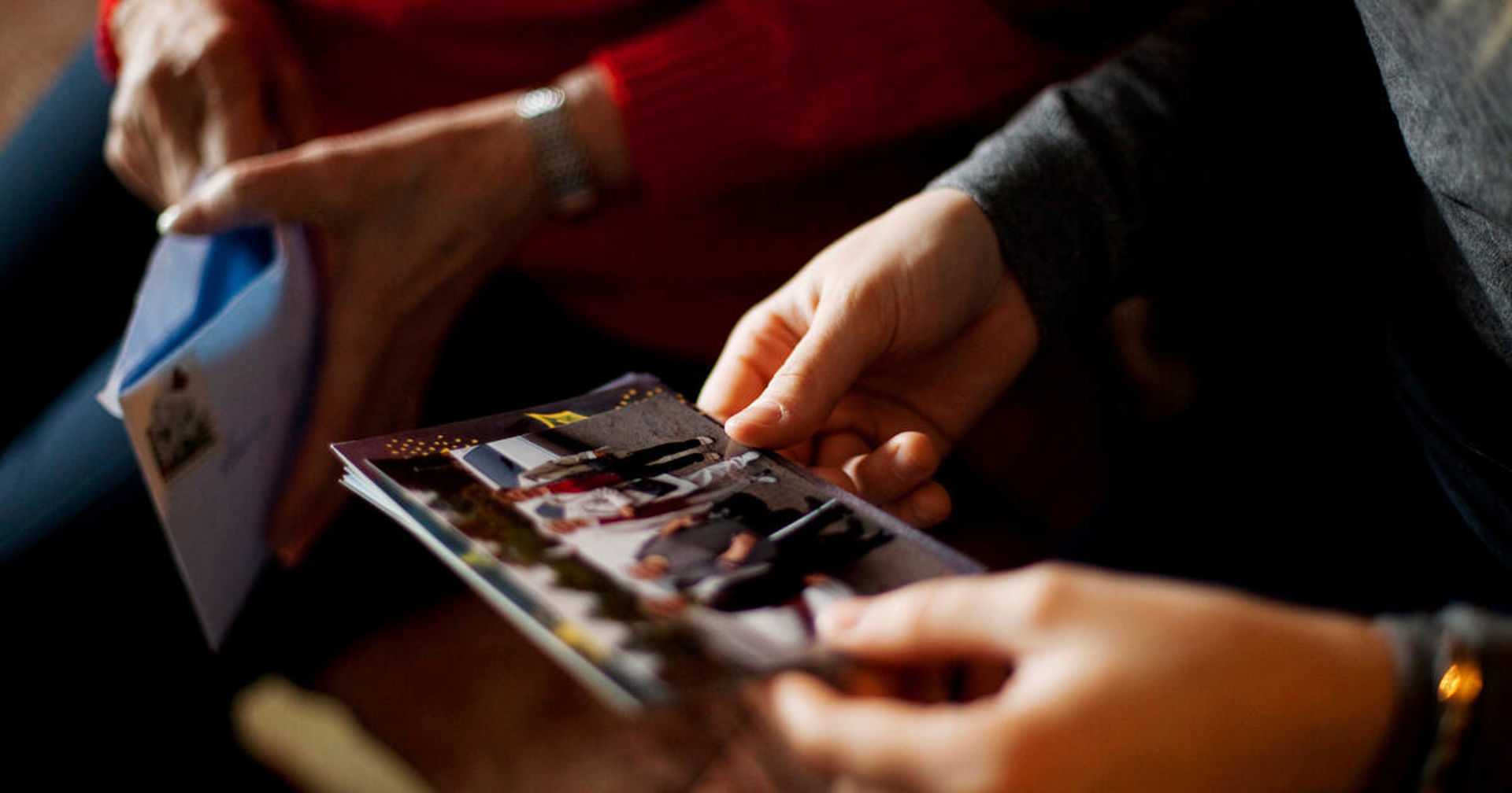 Valokuvia kädessä.