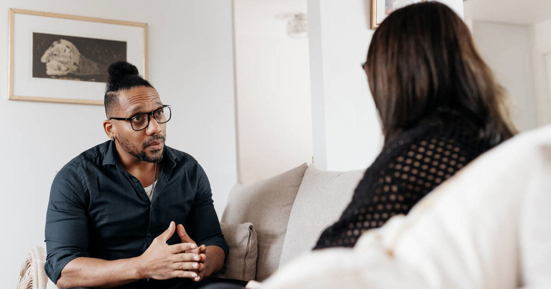 Nuori ja aikuinen juttelevat sohvalla.