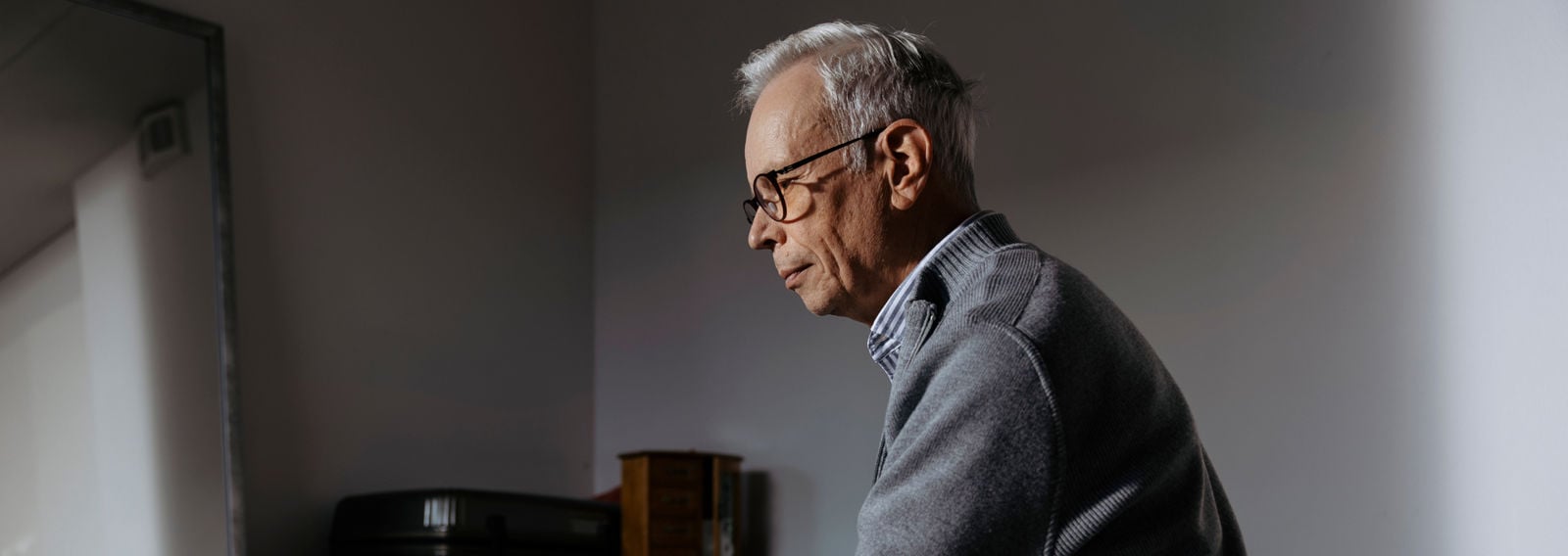 Henkilö istuu yksin sängyllä.